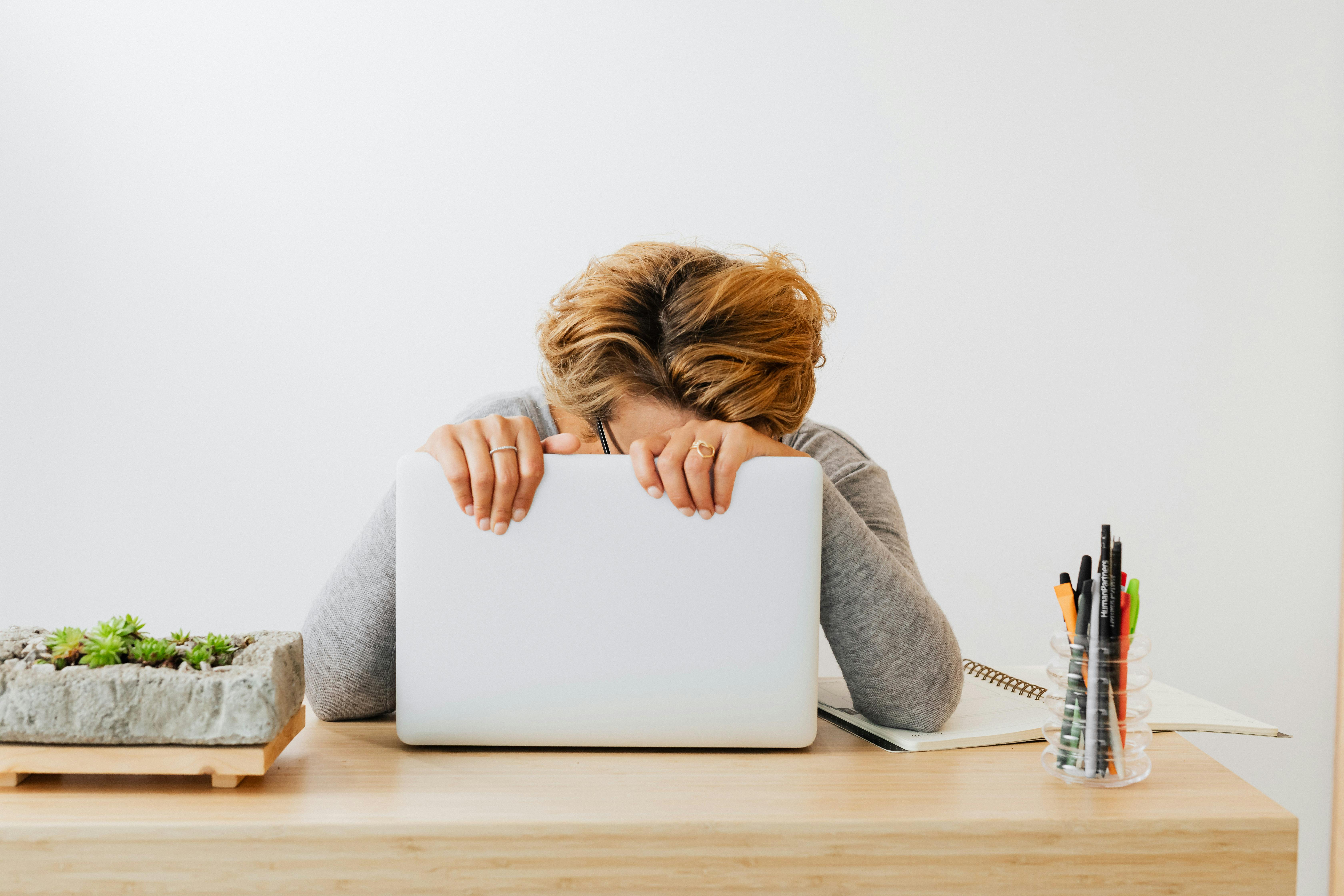 Person sitzt erschöpft vor einem Laptop als Bild für digitale Baustellen und Alltagsstress in kleinen Betrieben